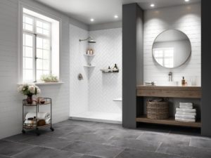 Newly remodeled bathroom with modern aesthetic, walk-in shower, gray tile flooring, and circular mirror above sink